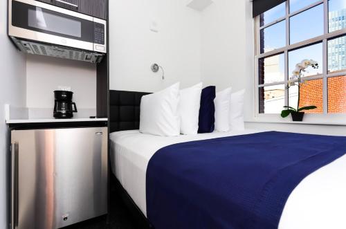 a hotel room with a bed and a microwave at Modern Studio in Historic Boston - Unit #401 in Boston