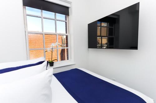 um quarto com um tapete azul e uma janela em Modern Studio in Historic Boston - Unit #401 em Boston
