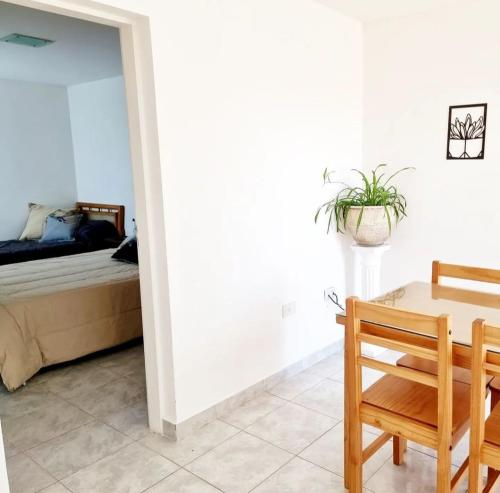 een slaapkamer met een bed, een tafel en een stoel bij Departamento WOOD in Caleta Olivia
