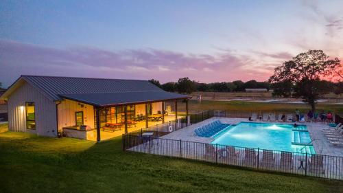 a house with a swimming pool in the yard at Great Escapes RV Resort Bryan College Station in Bryan