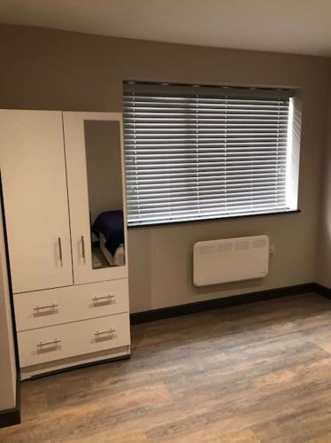 an empty room with a window and a chest of drawers at Bedfont House in New Bedfont