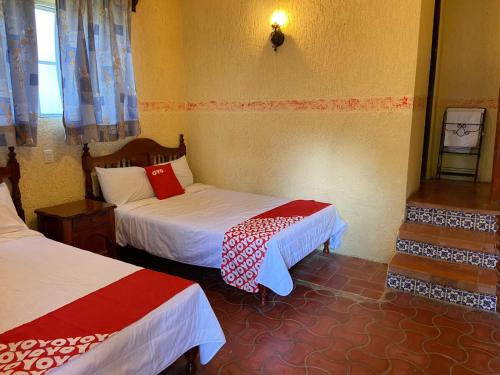 a hotel room with two beds and a window at Rancho Hotel El Carmen in Tlapacoyan