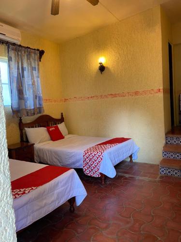 a hotel room with two beds and a window at Rancho Hotel El Carmen in Tlapacoyan