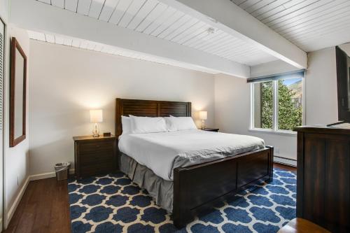 een slaapkamer met een groot bed en een raam bij Chateau Chaumont by Snowmass Vacations in Aspen