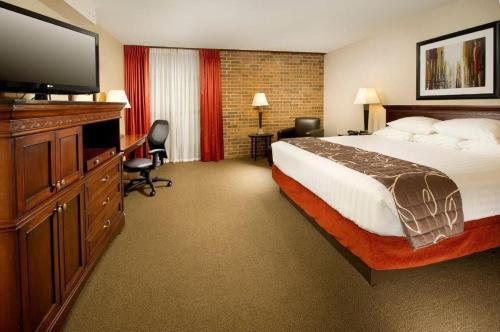 a hotel room with a bed and a flat screen tv at Hotel Lotus Kansas City Merriam in Merriam