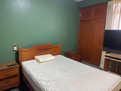 a bedroom with a bed and a flat screen tv at DEPAVICE in Piura