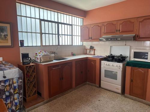 a kitchen with wooden cabinets and a white stove top oven at DEPAVICE in Piura