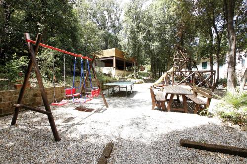 un parque infantil con un columpio y un banco en Hotel Valle Verde, en Procchio