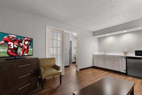 a living room with a television and a kitchen at Red Roof Inn & Suites Savannah Airport in Savannah