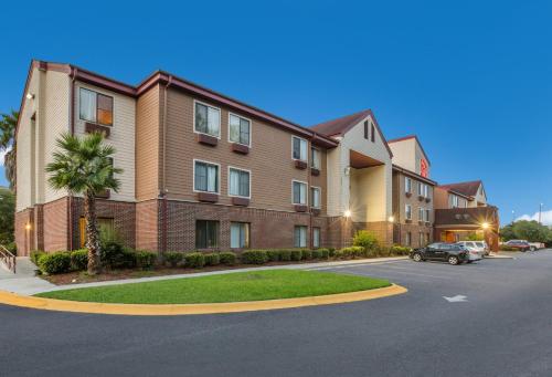 un edificio de apartamentos con un coche aparcado en un aparcamiento en Red Roof Inn & Suites Savannah Airport en Savannah