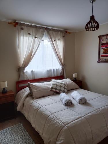 1 dormitorio con 1 cama grande y 2 toallas. en CASA EQUIPADA LAGO RANCO, en Lago Ranco