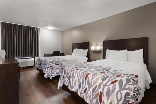 a hotel room with two beds and a window at Red Roof Inn & Suites Savannah Airport in Savannah