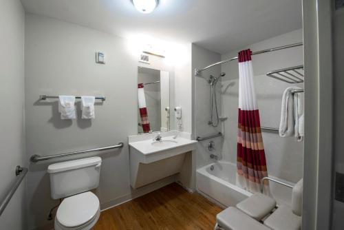 a bathroom with a toilet and a sink and a tub at Red Roof Inn & Suites Savannah Airport in Savannah