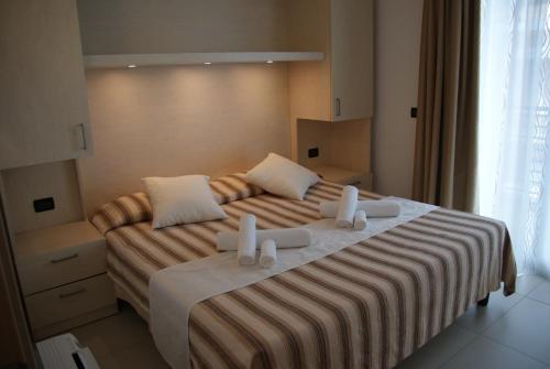 a bedroom with a large bed with two pillows at Residence Aprilia in Grado