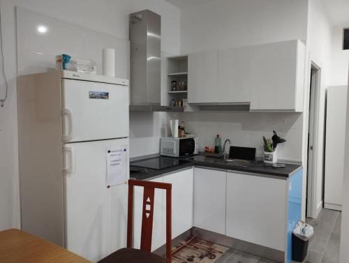 una cucina con armadietti bianchi e frigorifero bianco di Apartamento Carol a Reus