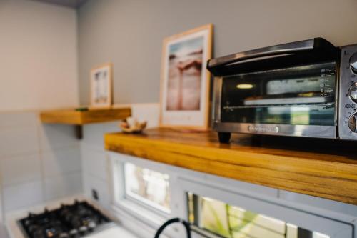 um micro-ondas sentado num balcão numa cozinha em Casa para 4 personas con A/C a 200 mts de la playa Low Tide - Popoyo Aparts em Tola