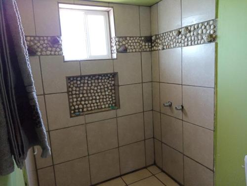 Un baño con ducha con ventana. en Departamento #7, en San Felipe