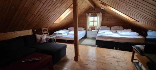 レイクホルトにあるGeysir - Modern Log Cabinのベッド2台とソファ1台が備わる屋根裏部屋です。