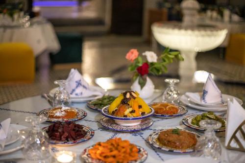 a table with many plates of food on it at Riad Fes Ziyat & Spa in Fès