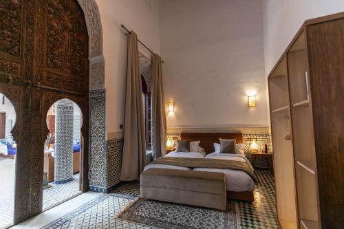 1 dormitorio con cama y puerta abovedada en Riad Fes Ziyat & Spa, en Fez