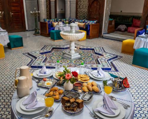 a table with plates of food on it at Riad Fes Ziyat & Spa in Fès