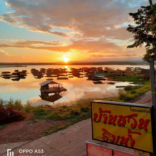 a group of boats on the water at sunset at บ้านสวนริมน้ำวังใหญ่ ห้อง a1 วังสามหมอ อุดรธานี in Ban Tha Ngam