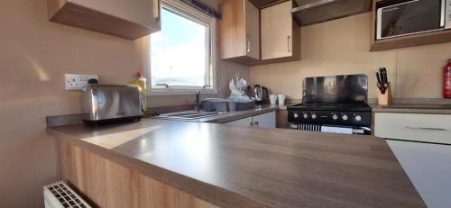 a kitchen with a wooden counter top in a kitchen at NB166 - Porth Bay Hideaway in Newquay Bay Resort