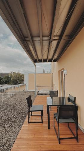 a patio with a table and chairs on a deck at Deichstadt Apartments in Neuwied