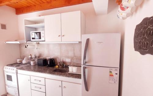 a kitchen with white cabinets and a white refrigerator at Amutuy Bariloche in San Carlos de Bariloche