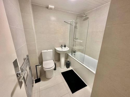 a bathroom with a toilet and a sink and a shower at Samara Stays - Long Booking Offers in Headingley