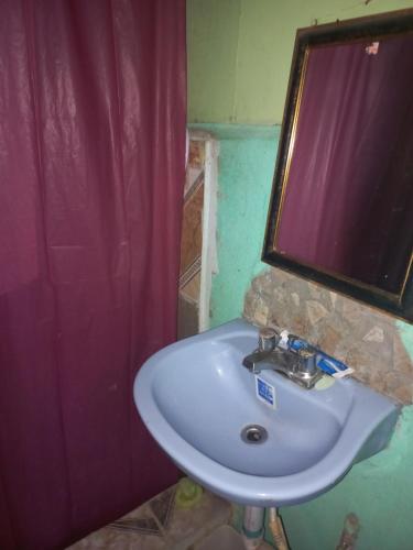 bagno con lavandino, finestra e doccia di Seaside Inn a Port Antonio