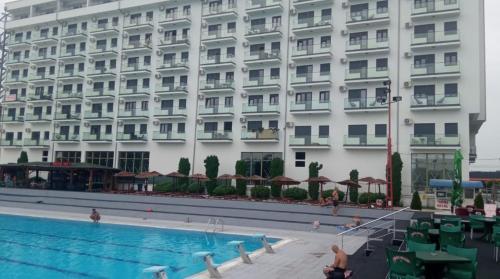 a hotel with a swimming pool in front of a building at cocoluxapartmanl73 in Trnava