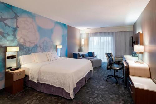 a hotel room with a bed and a desk and a couch at Courtyard by Marriott Scranton Montage Mountain in Moosic