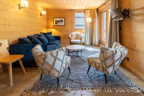 un salon avec un canapé bleu et des chaises dans l'établissement Cybèle 2, à Méribel