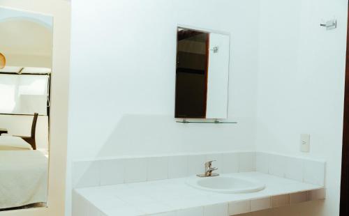 Baño blanco con lavabo y espejo en Bendito Teques, en Tequesquitengo