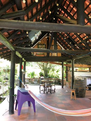 a hammock in a pavilion with a table and chairs at Rancheria Loft Chalet, lago privado in Rionegro