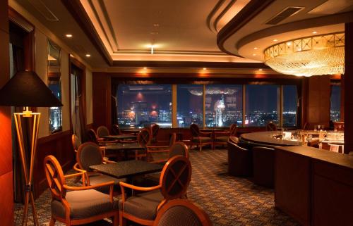 a restaurant with chairs and tables and a view of the city at ANA Crowne Plaza Toyama by IHG in Toyama