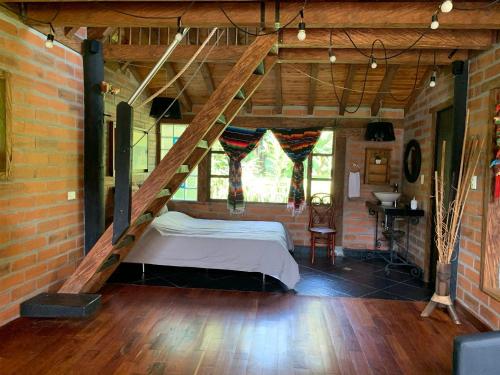 a bedroom with a bed in a brick wall at Rancheria Loft Chalet, lago privado in Rionegro