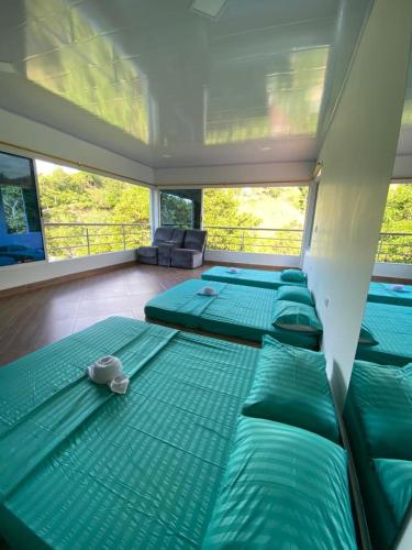 a room with several green beds in a room at CASA CAMPESTRE BELLO AMANECER in Puerto Triunfo