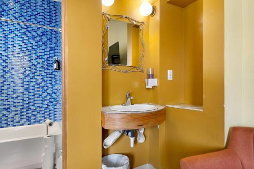 a bathroom with a sink and a mirror at Qupqugiaq Inn in Anchorage