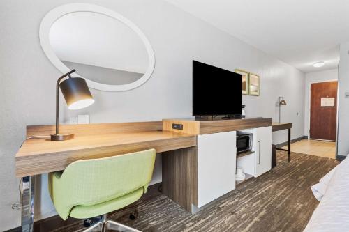 a room with a desk with a television and a chair at Hampton Inn & Suites Colorado Springs-Air Force Academy/I-25 North in Colorado Springs