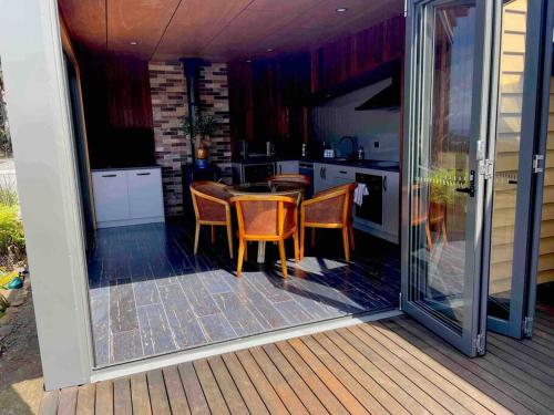 a kitchen with a table and chairs on a deck at Amaroo with a view set on a 50 Acre Hobby Farm in Collinsvale