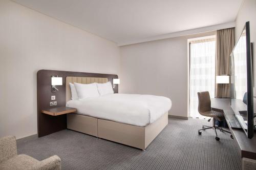 a bedroom with a bed and a desk and a chair at Hilton London Gatwick Airport in Horley
