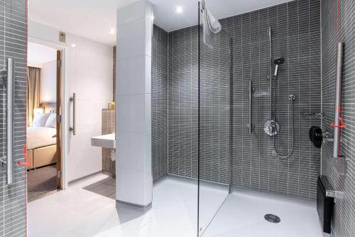 a bathroom with a shower with a glass door at Hilton London Gatwick Airport in Horley