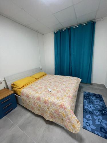 a bedroom with a bed and a blue curtain at Casa Ilaria in Elmas