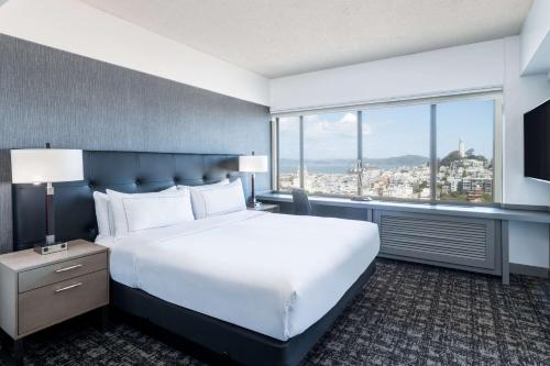 a bedroom with a large bed and a large window at Hilton San Francisco Financial District in San Francisco