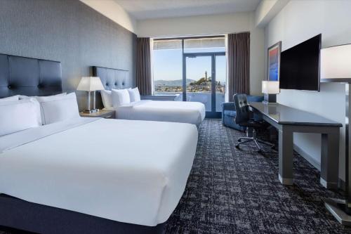 a hotel room with two beds and a desk at Hilton San Francisco Financial District in San Francisco