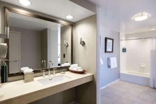 baño con lavabo y espejo grande en Hilton San Francisco Financial District, en San Francisco