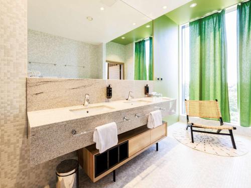 ein Badezimmer mit einem großen Waschbecken und einem Spiegel in der Unterkunft Mercure Tallinn in Tallinn