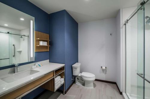 baño con paredes azules, aseo y lavamanos en Hilton Garden Inn Winnipeg South en Winnipeg